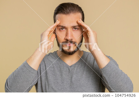 Lebanese man rubbing temples to cure headache problem suffering from tension and migaine stress pain 104754926