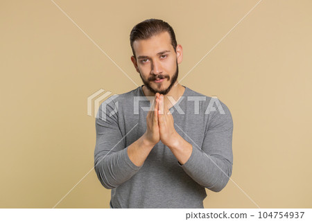 Man praying, looking upward, making wish, asking with hopeful imploring expression, begging apology 104754937