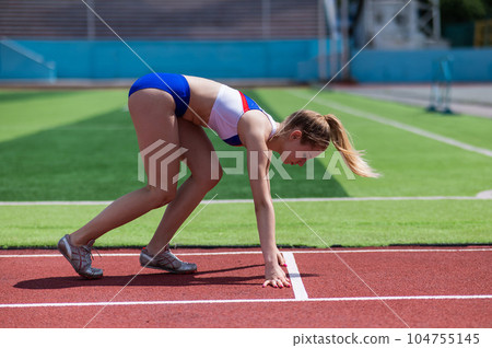Female runner in the stadium is ready to race. 104755145