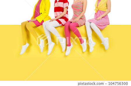 Women wearing bright tights sitting on color background, closeup 104756300