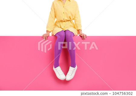 Woman wearing bright tights and stylish shoes sitting on color background, closeup Woman wearing bright tights and stylish shoes sitting on color background, closeup 104756302