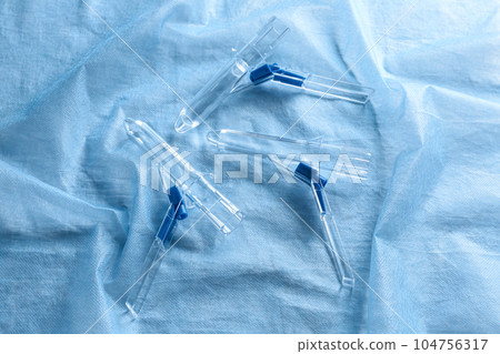 Anoscopes on light blue fabric, flat lay. Hemorrhoid treatment 104756317