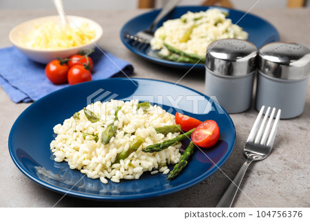 Delicious risotto with asparagus on grey table Delicious risotto with asparagus on grey table 104756376