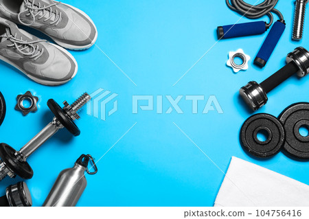Gym equipment on light blue background, flat lay. Space for text Gym equipment on light blue background, flat lay. Space for text 104756416