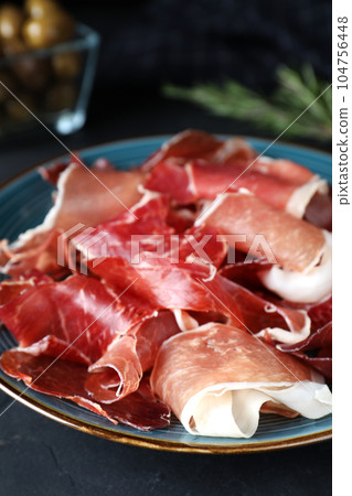 Tasty fresh prosciutto on black table, closeup 104756448