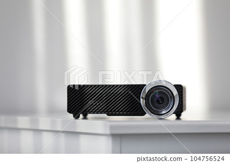 Modern video projector on white table indoors 104756524