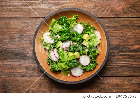 Delicious kale salad on wooden table, top view Delicious kale salad on wooden table, top view 104756555