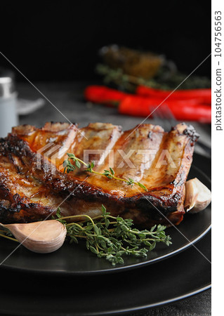 Tasty grilled ribs with thyme on table Tasty grilled ribs with thyme on table 104756563