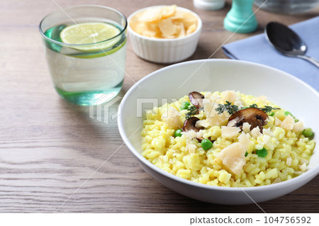 Delicious risotto with cheese and mushrooms on wooden table 104756592