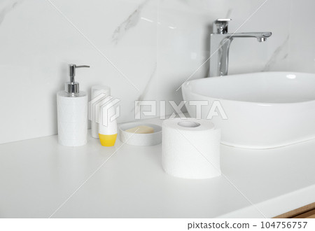 New toilet paper roll on countertop in bathroom New toilet paper roll on countertop in bathroom 104756757