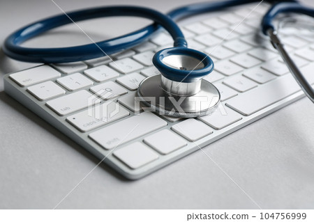 Keyboard and stethoscope on light grey table, closeup. Concept of technical support Keyboard and stethoscope on light grey table, closeup. Concept of technical support 104756999