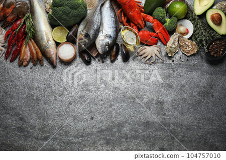 Fresh fish and different seafood on grey table, flat lay. Space for text 104757010