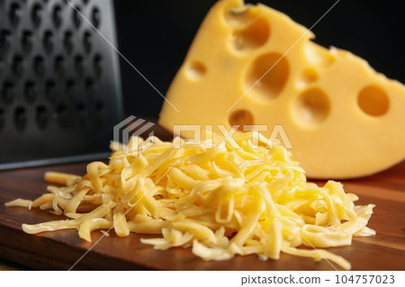 Tasty grated cheese on wooden table, closeup 104757023