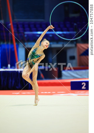 girl gymnast performs an exercise with a hoop 104757888