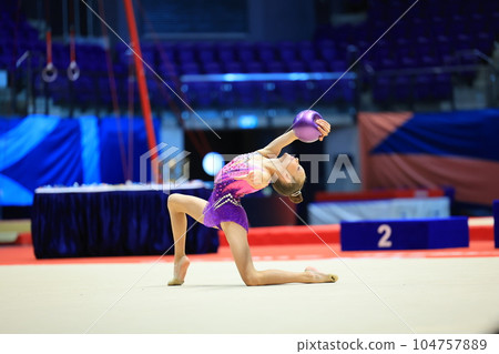 girl gymnast performs an exercise with a ball 104757889