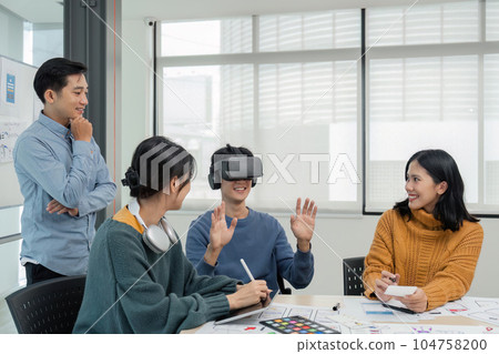 Diverse development team testing virtual reality headset, brainstorming on augmented reality improvement, future technology 104758200