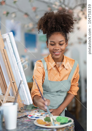 Female African artistartist painting art canvas drawing with inspiration at art studio art therapy creativity concept Female African artistartist painting art canvas drawing with inspiration at art studio art therapy creativity concept 104758339
