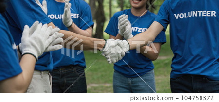 Environmentalist volunteers planting new tree and handshaking 104758372