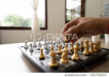 businessman hand moving gold Chess King figure and Checkmate opponent during chessboard competition. Strategy, Success, management, business planning, disruption and leadership concept businessman hand moving gold Chess King figure and Checkmate opponent during chessboard competition. Strategy, Success, management, business planning, disruption and leadership concept 104758654
