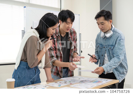 UX developer and UI designer brainstorming about app interface wireframe design on table with customer brief at modern office. Creative digital development agency 104758726