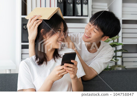 Relax, home couple on a couch, mobile phone and happiness with social media and connection. man and woman on a sofa, technology and loving with a smile, romance and reading 104758847