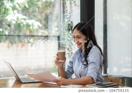 business woman holding a cup of coffee and document at office 104759135