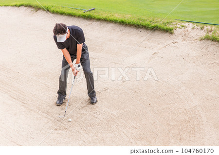 A golfer man who puts out a golf ball from a bunker (bunker shot) 104760170