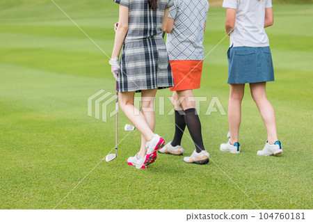 Golfer woman walking on golf course 104760181