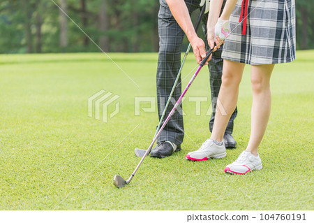 Golfer man and woman teaching golf at golf course Golfer man and woman teaching golf at golf course 104760191