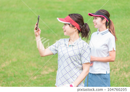 一名高爾夫球手在高爾夫球場使用智能手機拍攝視頻並檢查揮桿情況 一名高爾夫球手在高爾夫球場使用智能手機拍攝視頻並檢查揮桿情況 104760205