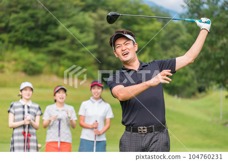 Man playing golf on golf course and female golfer watching swing 104760231