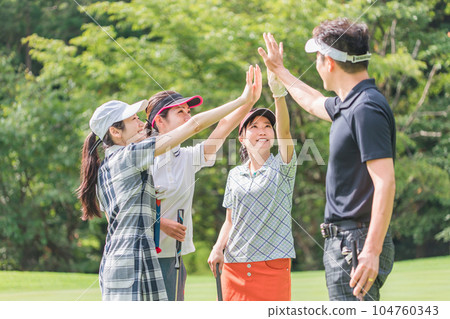 Men and women of golf buddies giving a high five at the golf course 104760343