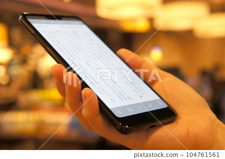 在咖啡館用智能手機閱讀小說 在咖啡館用智能手機閱讀小說 104761561