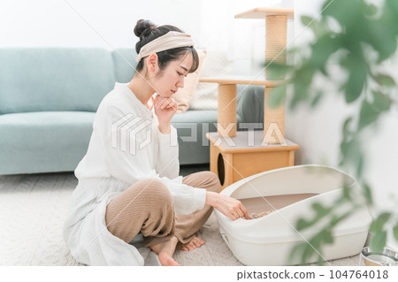 Asian woman cleaning cat litter in cat litter 104764018