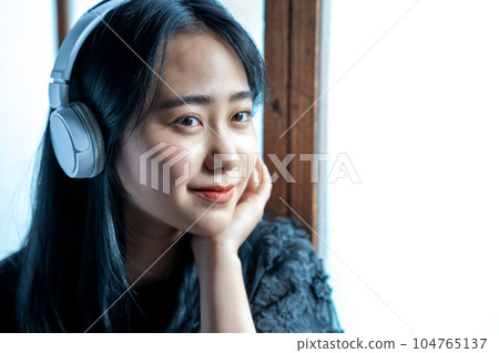聽到與耳機的音樂的一個少婦 104765137