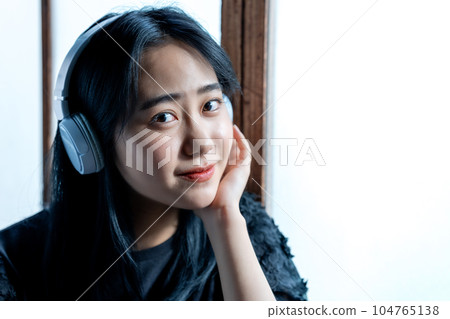 聽到與耳機的音樂的一個少婦 104765138