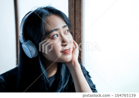 聽到與耳機的音樂的一個少婦 104765139