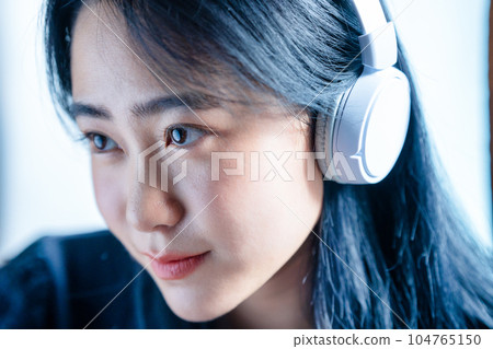 聽到與耳機的音樂的一個少婦 104765150