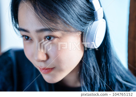 聽到與耳機的音樂的一個少婦 104765152