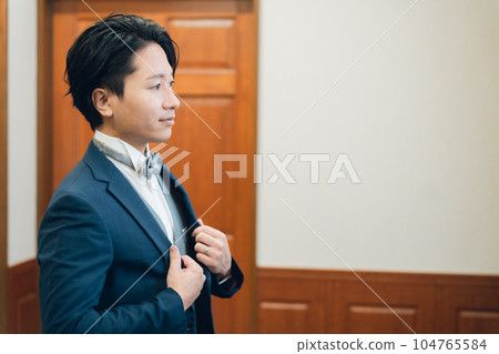 Groom/bridegroom (tuxedo) preparing for wedding/ceremony/reception in waiting room/brides room Groom/bridegroom (tuxedo) preparing for wedding/ceremony/reception in waiting room/brides room 104765584