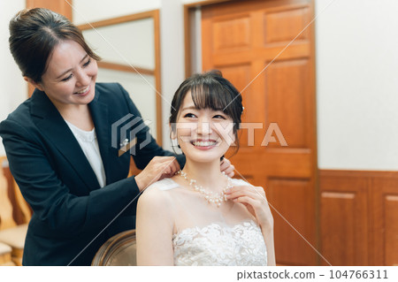 A bride and a bride wearing a wedding dress preparing for a wedding ceremony and reception in the bride's room and waiting room A bride and a bride wearing a wedding dress preparing for a wedding ceremony and reception in the bride's room and waiting room 104766311