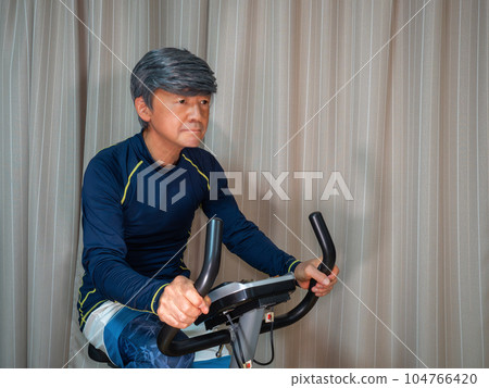 Senior man training on a fitness bike (exercise bike) Senior man training on a fitness bike (exercise bike) 104766420
