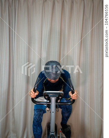 Senior man training on a fitness bike (exercise bike) Senior man training on a fitness bike (exercise bike) 104766556
