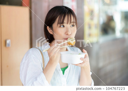 一個女人邊走邊吃 一個女人在旅行 一個女人在唐人街觀光 104767223