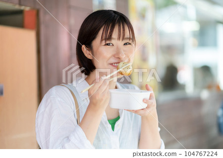 A woman eating while walking A woman traveling A woman sightseeing in Chinatown 104767224