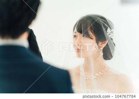 A bride and a crying father walk along a virgin road to the chapel where the groom waits at a wedding hall 104767784