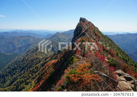 Mt. Tengudake of Mt. Ishizuchi covered in autumn leaves against a clear blue sky Ver1 104767813
