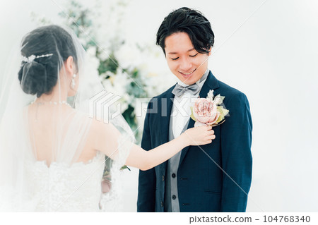 The groom who has the bride wear a boutonniere at the wedding ceremony (boutonniere ceremony) The groom who has the bride wear a boutonniere at the wedding ceremony (boutonniere ceremony) 104768340