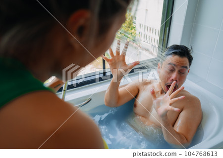 Funny playful asian couple lover play in the bathtub in the bathroom. Funny playful asian couple lover play in the bathtub in the bathroom. 104768613