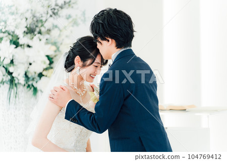 A bride and groom kissing a vow in a chapel/church (wedding/bridal) A bride and groom kissing a vow in a chapel/church (wedding/bridal) 104769412